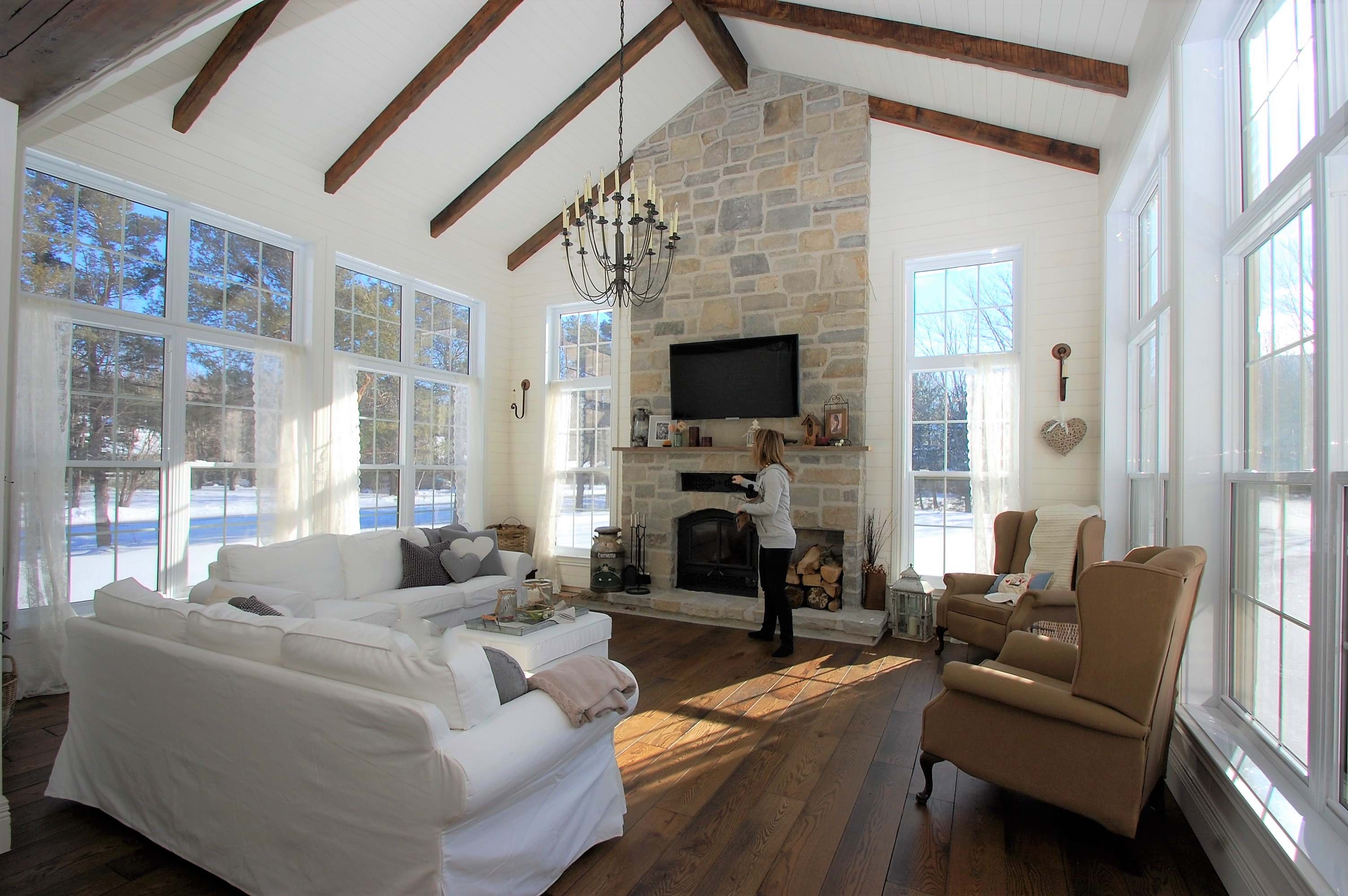 Salle familiale avec plafond cathédrale et foyer de pierre taillées.